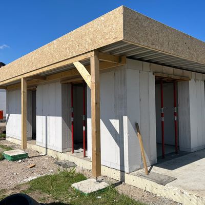 Rohbau der Praxis mit Holzkonstruktion für den Dachüberstand
