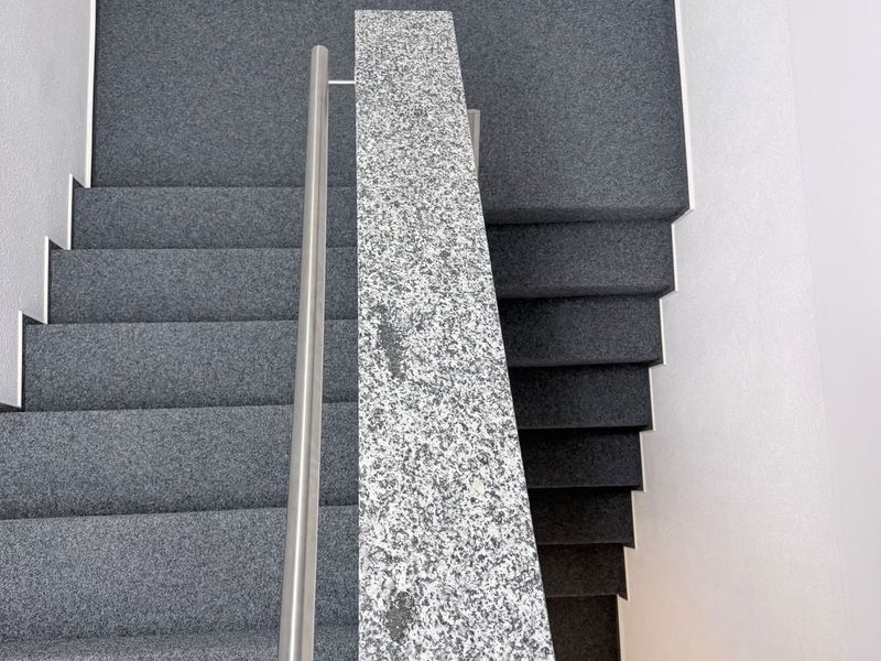 Neue Treppenanlage der Zahnarztpraxis mit Granitabdeckung und Edelstahl-Handlauf